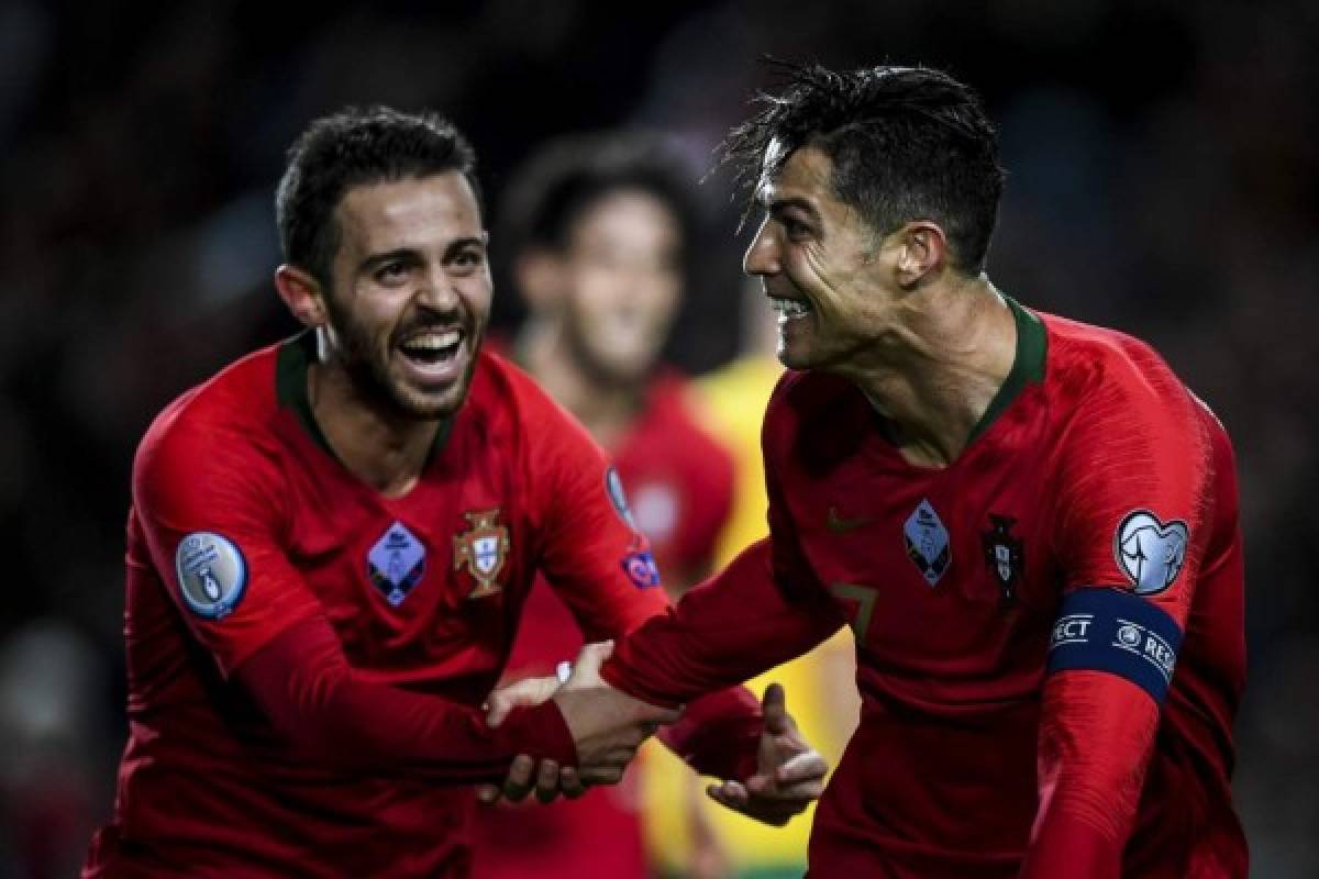 Portugal's forward Cristiano Ronaldo (R) celebrates with his teammate Portugal's forward Bernardo Silva (L) after scoring during the Euro 2020 Group B football qualification match between Portugal and Lithuania at the Algarve stadium in Faro, on November 14, 2019. (Photo by PATRICIA DE MELO MOREIRA / AFP)