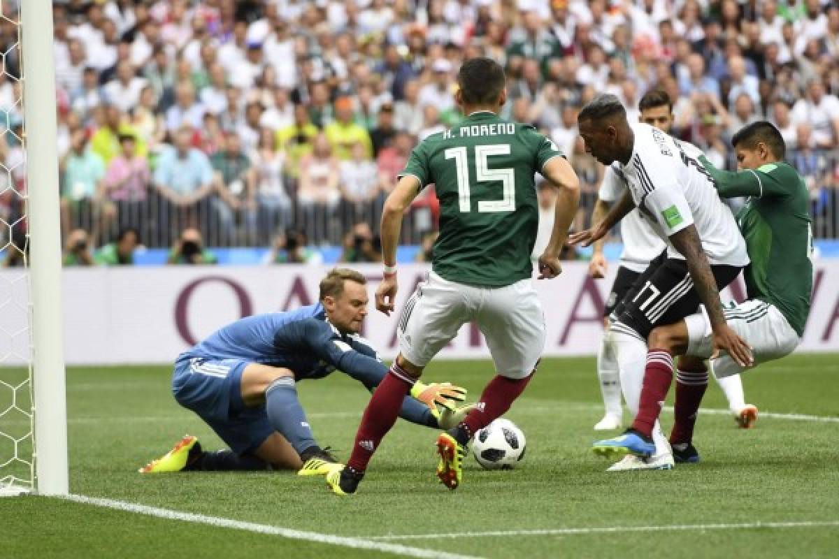 Germany's goalkeeper Manuel Neuer (L) attempts to catch the ball as he vies with Mexico's defender Hector Moreno (C) during the Russia 2018 World Cup Group F football match between Germany and Mexico at the Luzhniki Stadium in Moscow on June 17, 2018. / AFP PHOTO / PATRIK STOLLARZ / RESTRICTED TO EDITORIAL USE - NO MOBILE PUSH ALERTS/DOWNLOADS