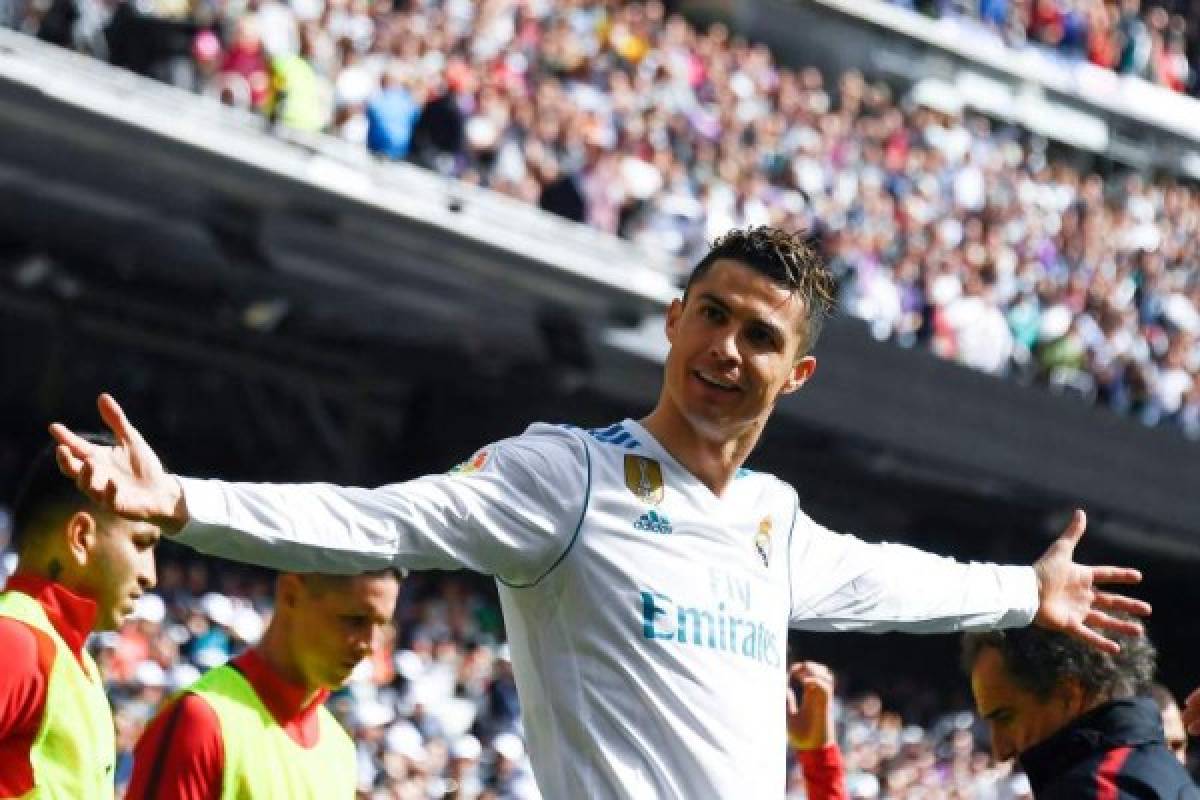 Real Madrid's Portuguese forward Cristiano Ronaldo celebrates after scoring a goal during the Spanish league football match between Real Madrid CF and Club Atletico de Madrid at the Santiago Bernabeu stadium in Madrid on April 8, 2018. / AFP PHOTO / GABRIEL BOUYS