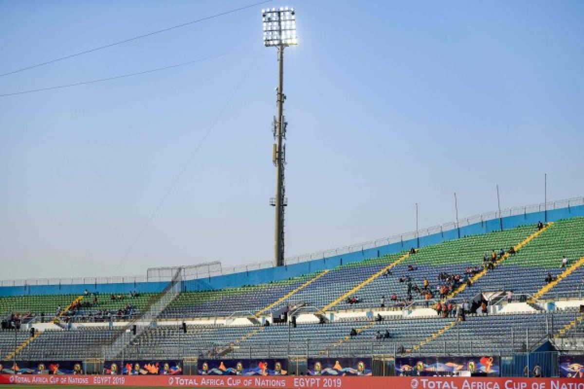 This picture shows empty stands prior to the 2019 Africa Cup of Nations (CAN) football match between Senegal and Algeria at the June 30 Stadium in Cairo on June 27, 2019. - Apart from the host country matches, the 2019 Africa Cup of Nations stadia very often ring hollow. Since its start, the spectrum of security tensions that has accompanied this CAN edition and the prohibitive prices of seats may have deterred spectators from attending. (Photo by Khaled DESOUKI / AFP) / TO GO WITH AFP STORY ON EMPTY STADIUMS