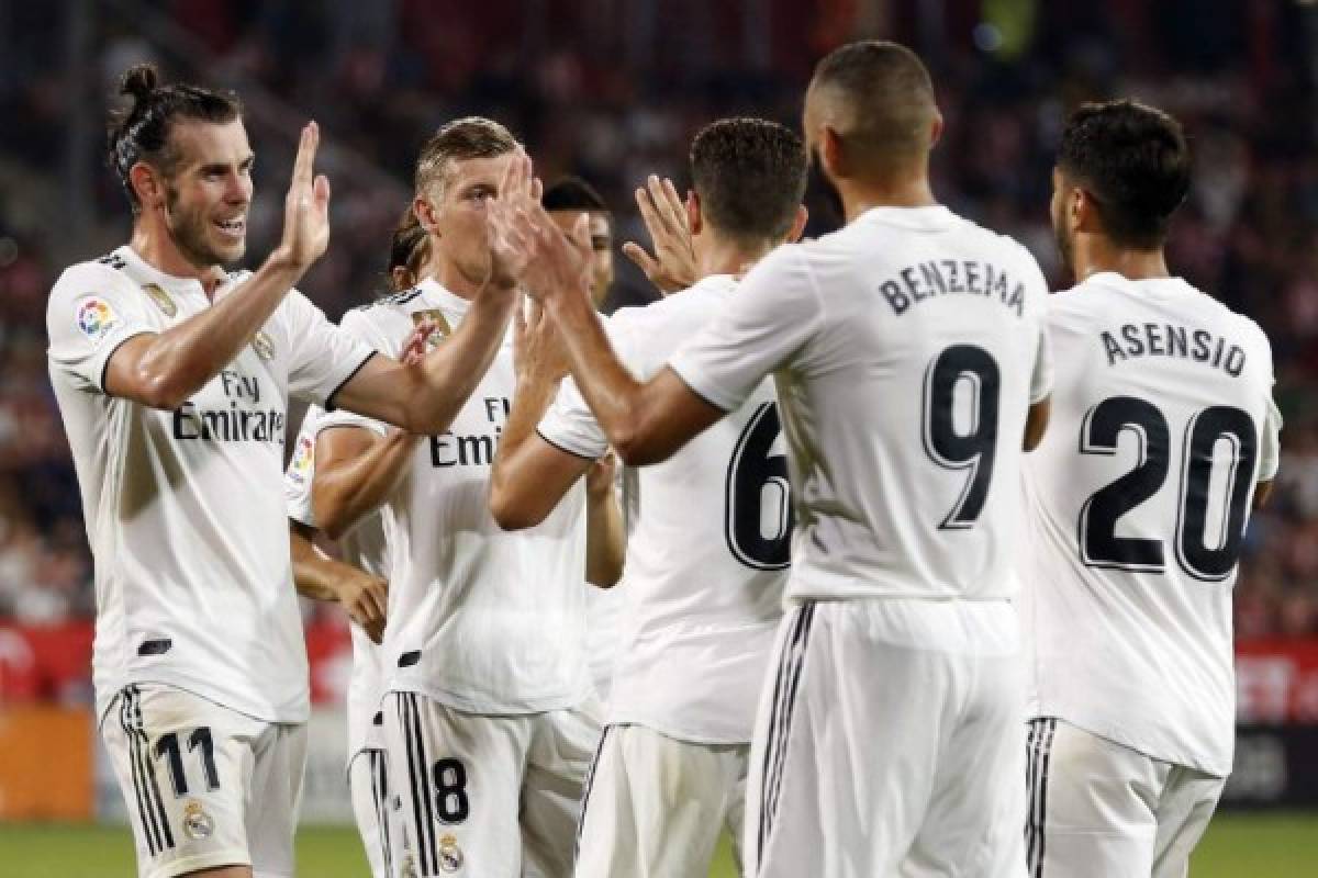 Real Madrid players celebrate their fourth goal scored by Real Madrid's French forward Karim Benzema during the Spanish league football match between Girona FC and Real Madrid CF at the Montilivi stadium in Girona on August 26, 2018. / AFP PHOTO / Pau BARRENA CAPILLA