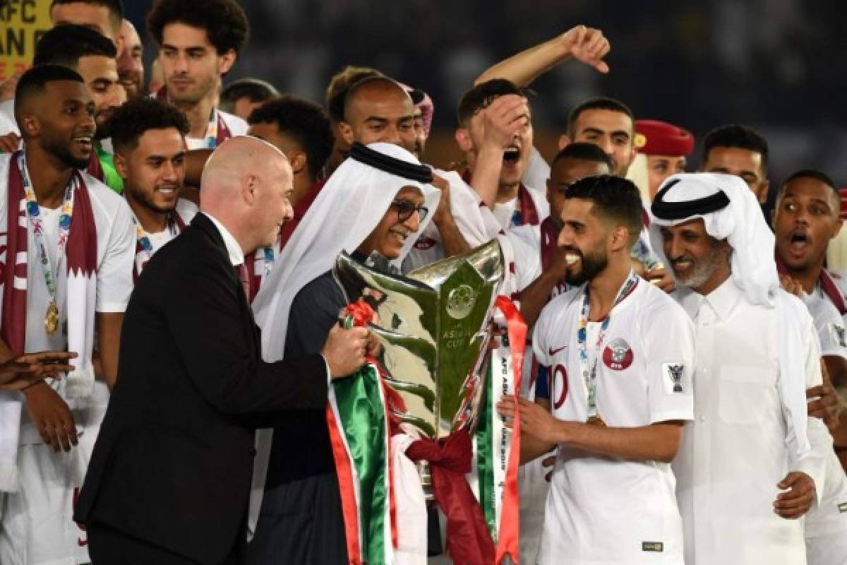 FIFA President Gianni Infantino (L) and AFC President Salman Al-Khalifa (2nd-L) present the cup to Qatar's forward Hasan Al Haydos (2nd-R) during the 2019 AFC Asian Cup final football match between Japan and Qatar at the Mohammed Bin Zayed Stadium in Abu Dhabi on February 1, 2019. (Photo by Roslan RAHMAN / AFP)