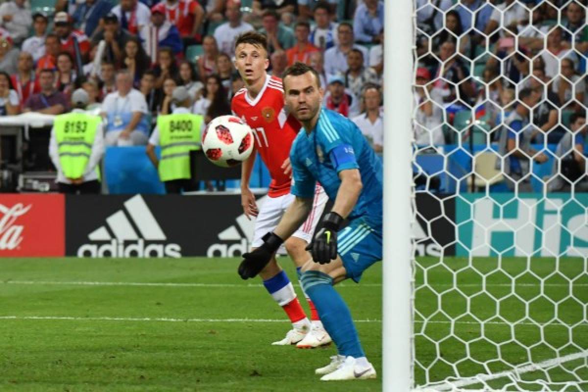 Russia's goalkeeper Igor Akinfeev (R) watches the ball as he concedes during the Russia 2018 World Cup quarter-final football match between Russia and Croatia at the Fisht Stadium in Sochi on July 7, 2018. / AFP PHOTO / Nelson Almeida / RESTRICTED TO EDITORIAL USE - NO MOBILE PUSH ALERTS/DOWNLOADS