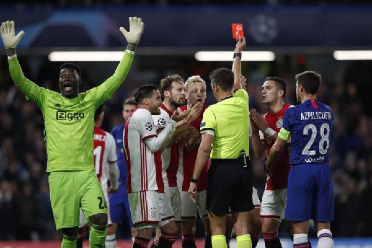 Ajax's players react after Ajax's Dutch defender Joel Veltman (hidden) is shown a red card by Italian referee Gianluca Rocchi during the UEFA Champion's League Group H football match between Chelsea and Ajax at Stamford Bridge in London on November 5, 2019. - The game finished 4-4. (Photo by Adrian DENNIS / AFP)