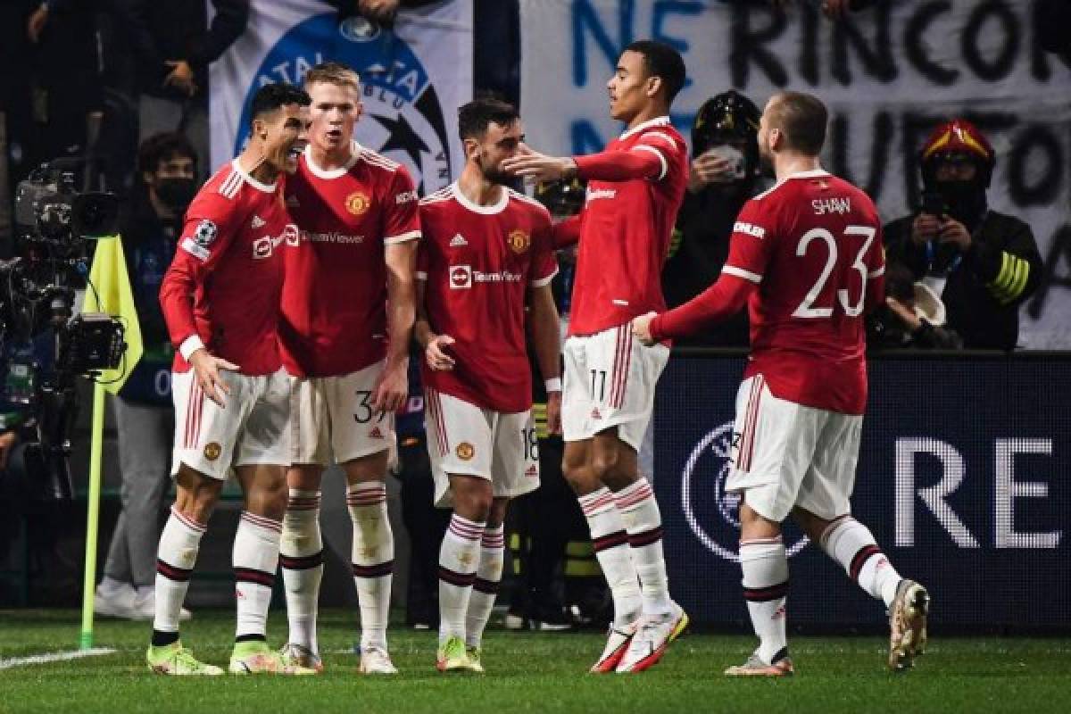 Manchester United's Portugal's forward Cristiano Ronaldo (L) celebrates with teammates after scoring a goal during the UEFA Champions League group F football match between Atalanta and Manchester United at the Azzurri d'Italia stadium, in Bergamo, on November 2, 2021. (Photo by Marco BERTORELLO / AFP)