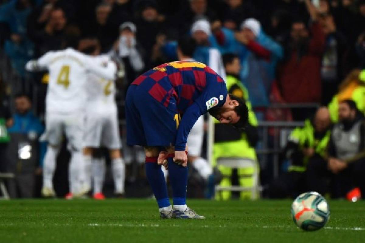 Barcelona's Argentine forward Lionel Messi reacts as Real Madrid's players celebrate a goal during the Spanish League football match between Real Madrid and Barcelona at the Santiago Bernabeu stadium in Madrid on March 1, 2020. (Photo by GABRIEL BOUYS / AFP)