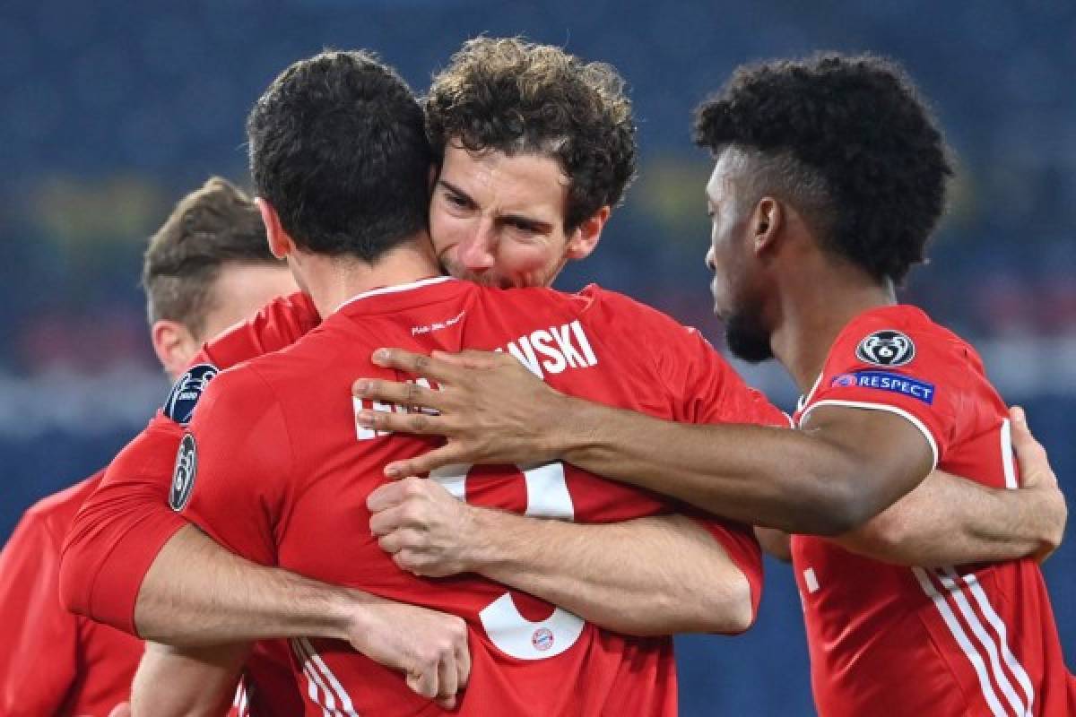 Bayern Munich's German midfielder Leon Goretzka (C) embraces Bayern Munich's Polish forward Robert Lewandowski after Lewandowski opened the scoring during the UEFA Champions League round of 16 first leg football match Lazio Rome vs Bayern Munich on February 23, 2021 at the Olympic stadium in Rome. (Photo by Alberto PIZZOLI / AFP)