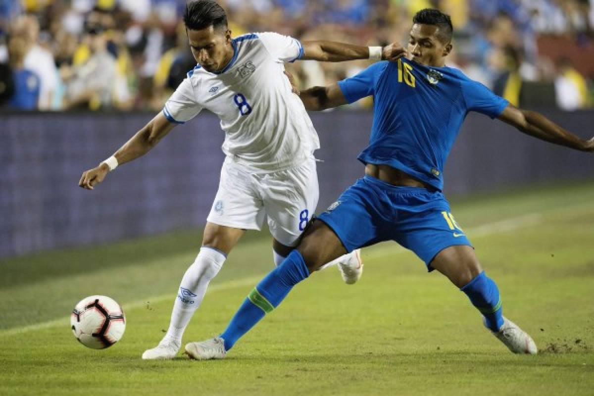 Brazil's Alex Sandro (R) vies for the ball against El Salvador's Denis Pineda Torres during an international friendly at FedEx Field in Landover, MD, on September 11, 2018. / AFP PHOTO / JIM WATSON