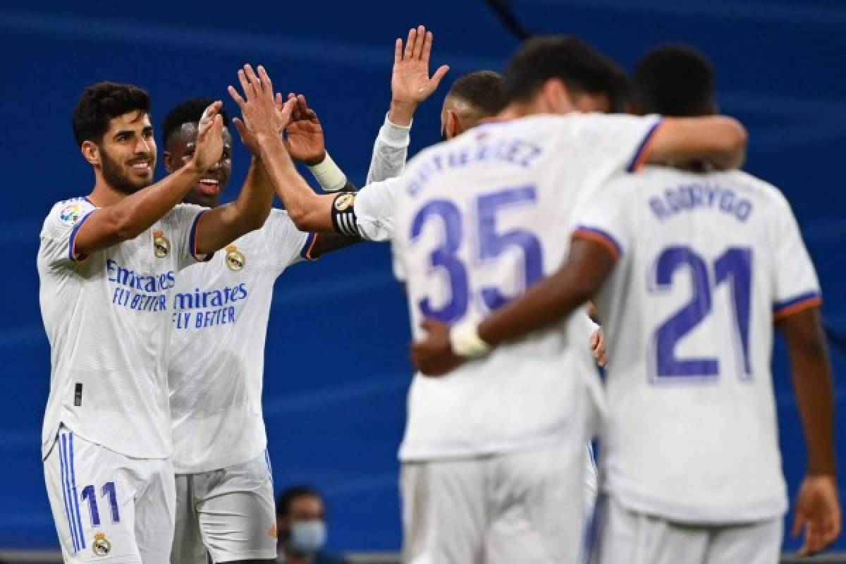 Real Madrid's Spanish midfielder Marco Asensio (L) celebrates scoring his team's second goal during the Spanish League footbal match between Real Madrid CF and Real Mallorca at the Santiago Bernabeu stadium in Madrid on September 22, 2021. (Photo by GABRIEL BOUYS / AFP)