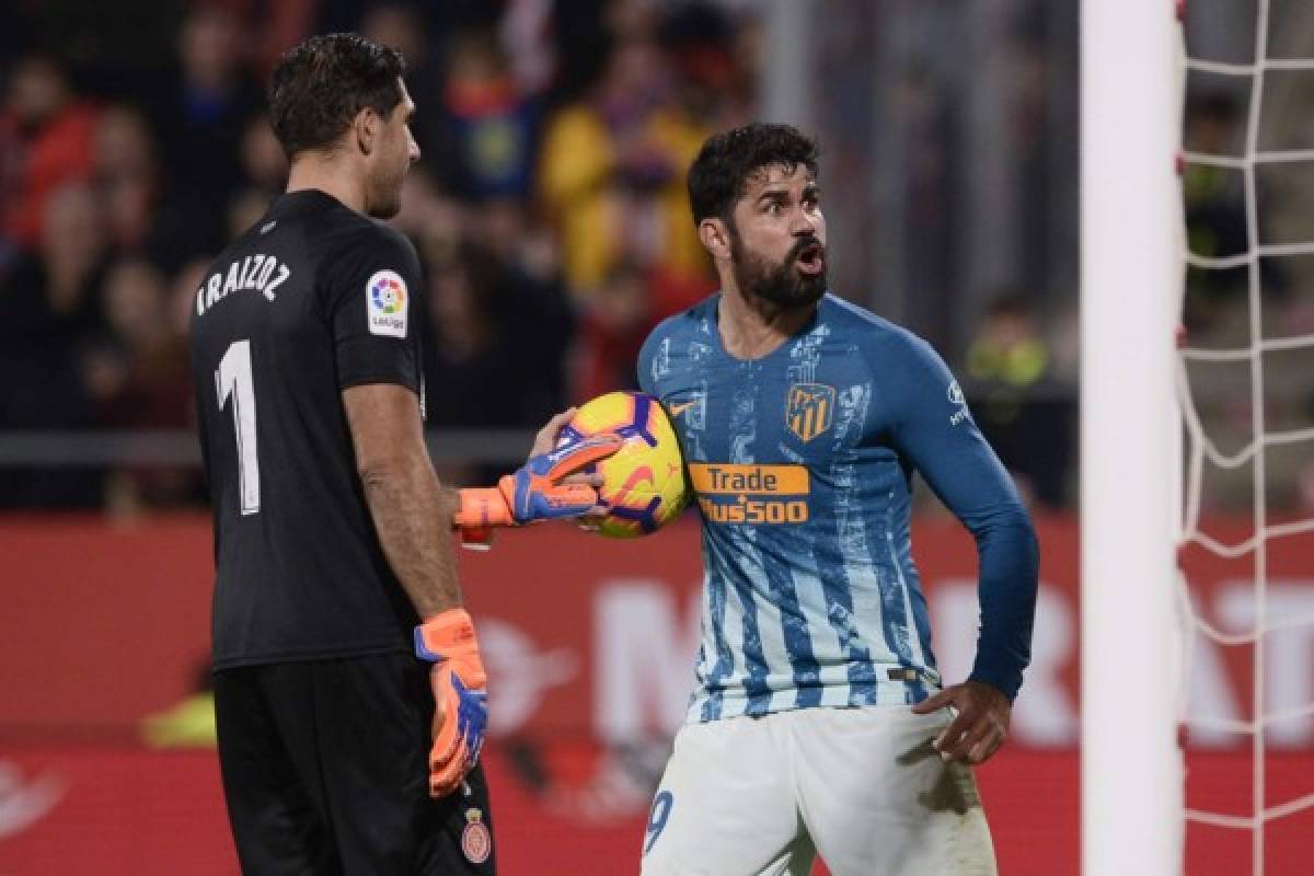 Atletico Madrid's Spanish forward Diego Costa celebrates next to Girona's Spanish goalkeeper Gorka Iraizoz (L) after scoring a goal during the Spanish league football match between Girona and Club Atletico de Madrid at the Montilivi stadium in Girona on December 2, 2018. (Photo by Josep LAGO / AFP)