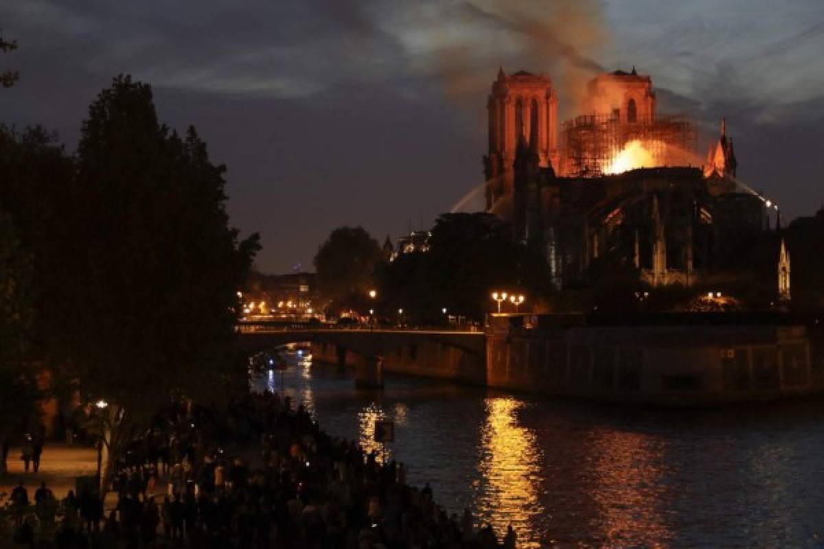 Firefighters douse flames billowing from the roof at Notre-Dame Cathedral in Paris on April 15, 2019. - A fire broke out at the landmark Notre-Dame Cathedral in central Paris, potentially involving renovation works being carried out at the site, the fire service said. (Photo by Thomas SAMSON / AFP)