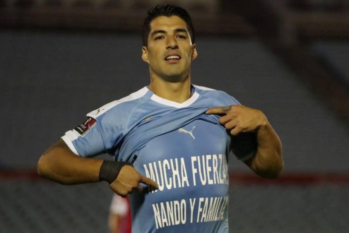 Uruguay's Luis Suarez shows a t-shirt reading 'Stay Strong Nando and Family' after scoring a penalty against Chile during their 2022 FIFA World Cup South American qualifier football match at the Centenario Stadium in Montevideo on October 8, 2020, amid the COVID-19 novel coronavirus pandemic. (Photo by Raul MARTINEZ / POOL / AFP)