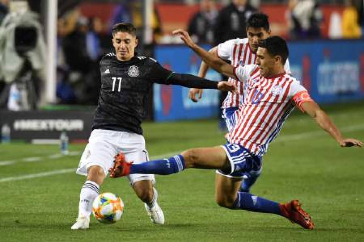 Mexico's Isaac Brizuela (L) fights for the ball with Paraguay's Junior Alonso during the international friendly match between Mexico and Paraguay at Levi's Stadium in Santa Clara, California, on March 26, 2019. (Photo by Robyn Beck / AFP)