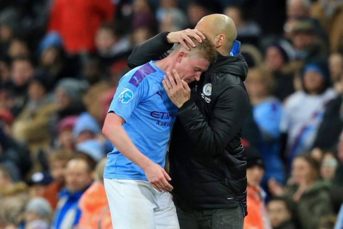 Manchester City's Spanish manager Pep Guardiola (R) embraces Manchester City's Belgian midfielder Kevin De Bruyne as he leaves the pitch substituted during the English Premier League football match between Manchester City and West Ham United at the Etihad Stadium in Manchester, north west England, on February 19, 2020. (Photo by Lindsey Parnaby / AFP) / RESTRICTED TO EDITORIAL USE. No use with unauthorized audio, video, data, fixture lists, club/league logos or 'live' services. Online in-match use limited to 120 images. An additional 40 images may be used in extra time. No video emulation. Social media in-match use limited to 120 images. An additional 40 images may be used in extra time. No use in betting publications, games or single club/league/player publications. /