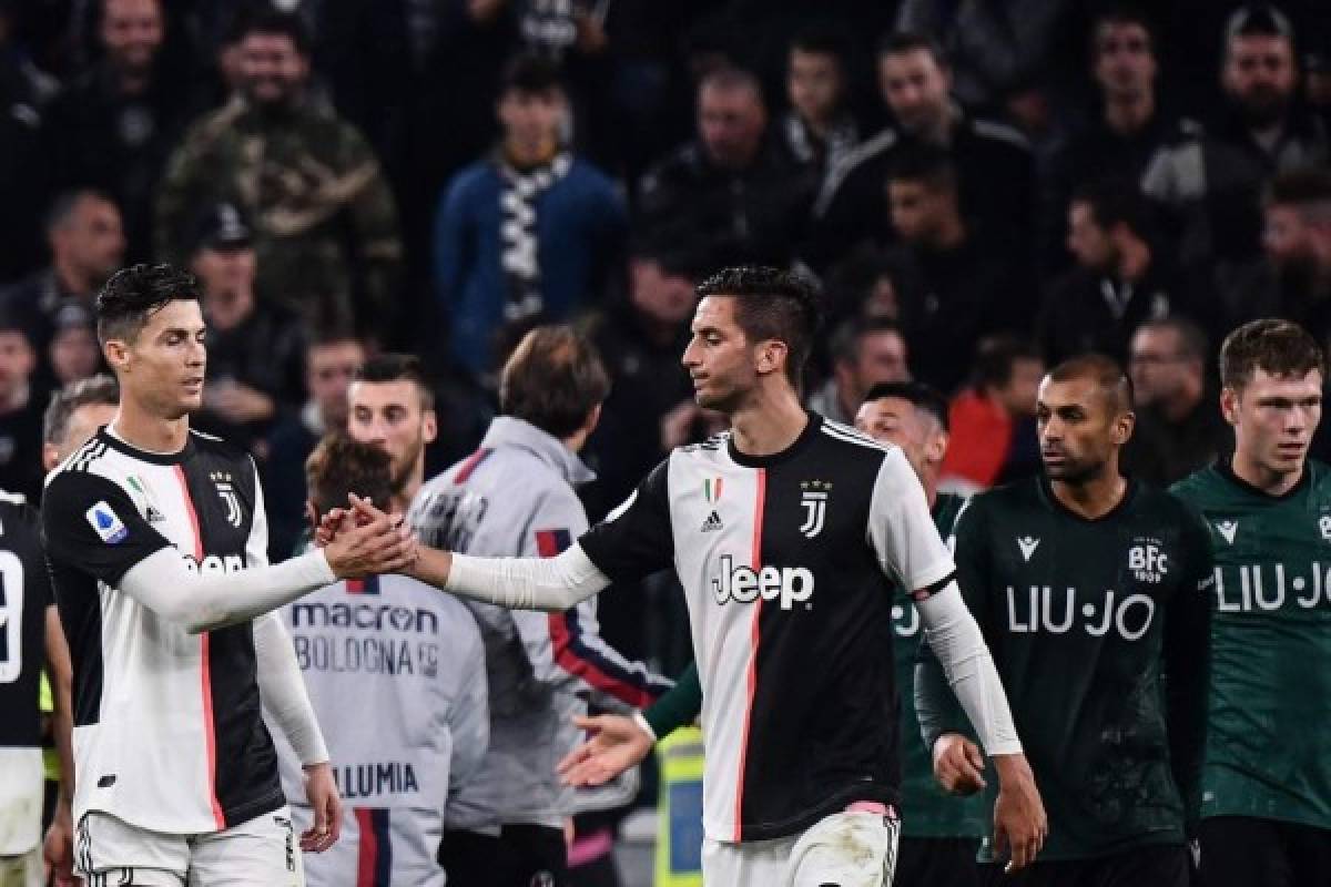 Juventus' Portuguese forward Cristiano Ronaldo (L) and Juventus' Uruguayan midfielder Rodrigo Bentancur tap hands at the end of the Italian Serie A football match Juventus vs Bologna on October 19, 2019 at the Juventus stadium in Turin. (Photo by Marco Bertorello / AFP)