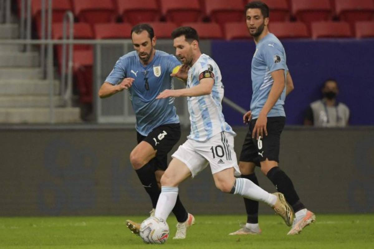 Argentina's Lionel Messi (C) is marked by Uruguay's Diego Godin (L) during their Conmebol Copa America 2021 football tournament group phase match at the Mane Garrincha Stadium in Brasilia, on June 18, 2021. (Photo by NELSON ALMEIDA / AFP)
