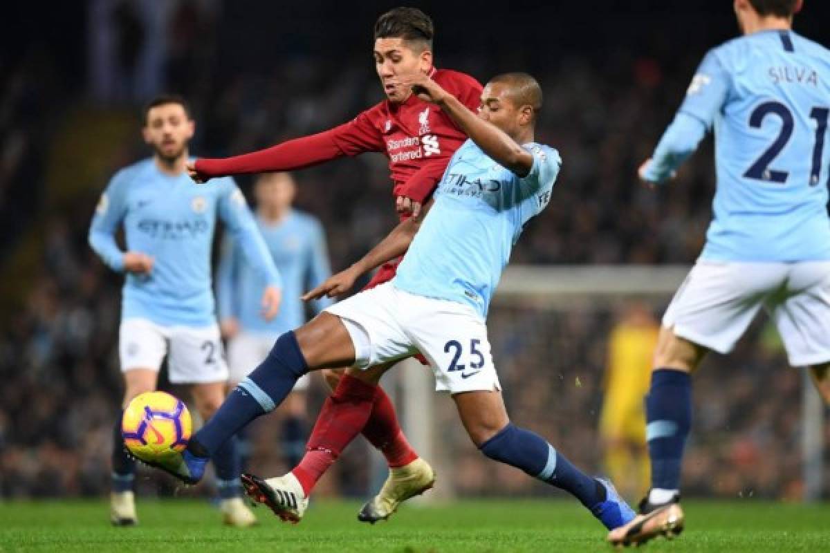 Liverpool's Brazilian midfielder Roberto Firmino vies with Manchester City's Brazilian midfielder Fernandinho (2nd R) during the English Premier League football match between Manchester City and Liverpool at the Etihad Stadium in Manchester, north west England, on January 3, 2019. (Photo by Paul ELLIS / AFP) / RESTRICTED TO EDITORIAL USE. No use with unauthorized audio, video, data, fixture lists, club/league logos or 'live' services. Online in-match use limited to 120 images. An additional 40 images may be used in extra time. No video emulation. Social media in-match use limited to 120 images. An additional 40 images may be used in extra time. No use in betting publications, games or single club/league/player publications. /