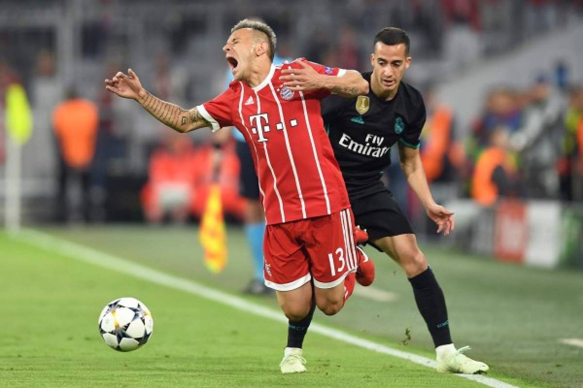 Real Madrid's Spanish midfielder Lucas Vazquez (L) fouls Bayern Munich's Brazilian defender Rafinha during the UEFA Champions League semi-final first-leg football match FC Bayern Munich v Real Madrid CF in Munich in southern Germany on April 25, 2018. / AFP PHOTO / Christof STACHE