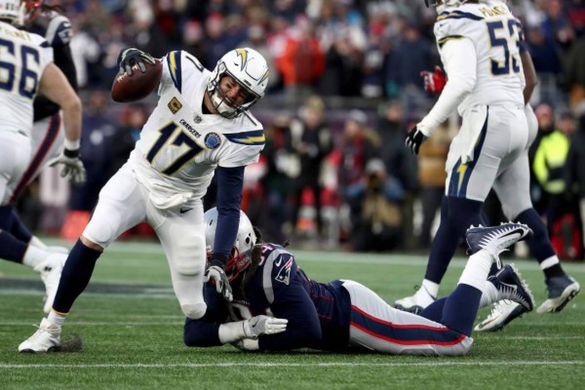 FOXBOROUGH, MASSACHUSETTS - JANUARY 13: Philip Rivers #17 of the Los Angeles Chargers is tackled by Adrian Clayborn #94 of the New England Patriots during the fourth quater in the AFC Divisional Playoff Game at Gillette Stadium on January 13, 2019 in Foxborough, Massachusetts. Al Bello/Getty Images/AFP