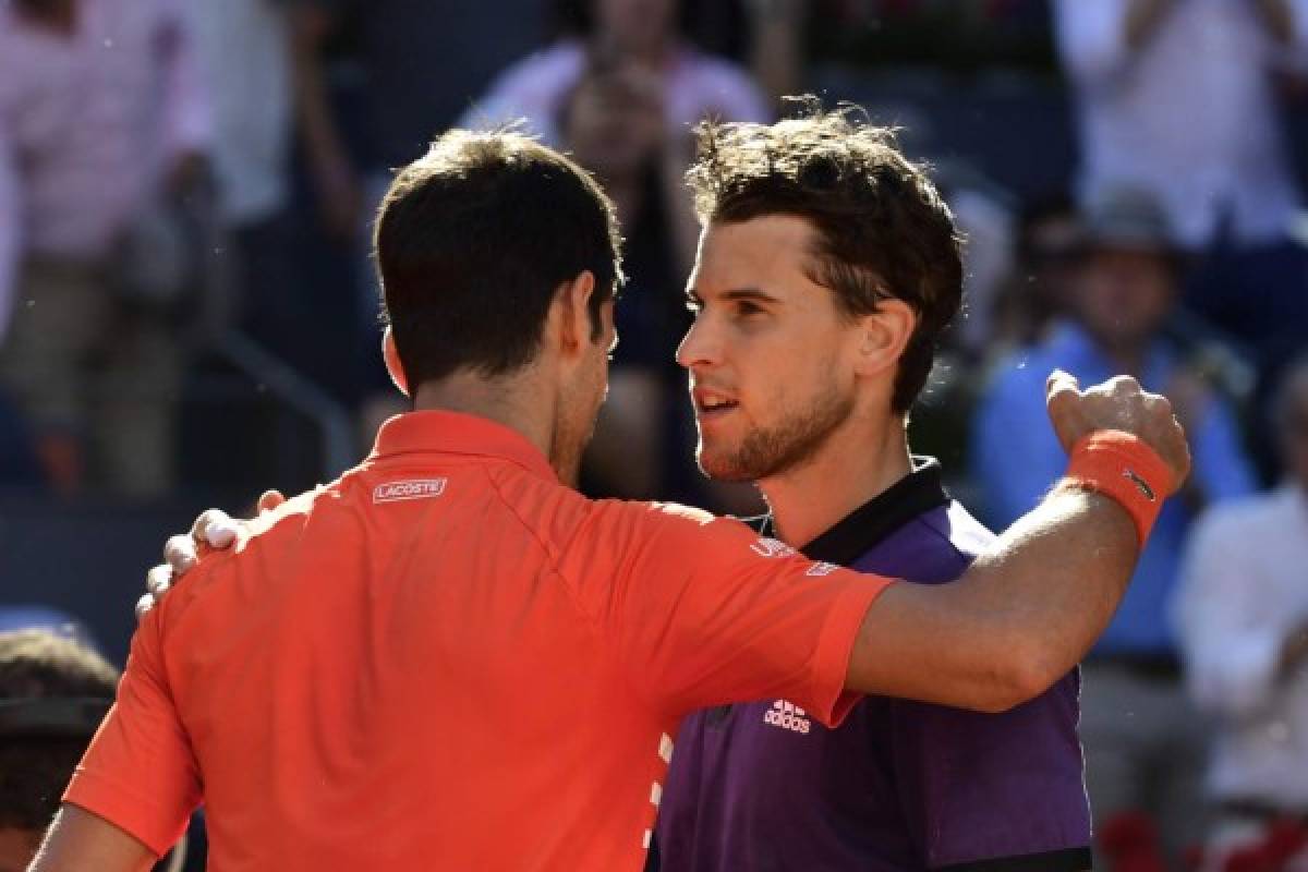 Serbia's Novak Djokovic (L) greets Austria's Dominic Thiem after their ATP Madrid Open semi-final tennis match at the Caja Magica in Madrid on May 11, 2019. (Photo by JAVIER SORIANO / AFP)
