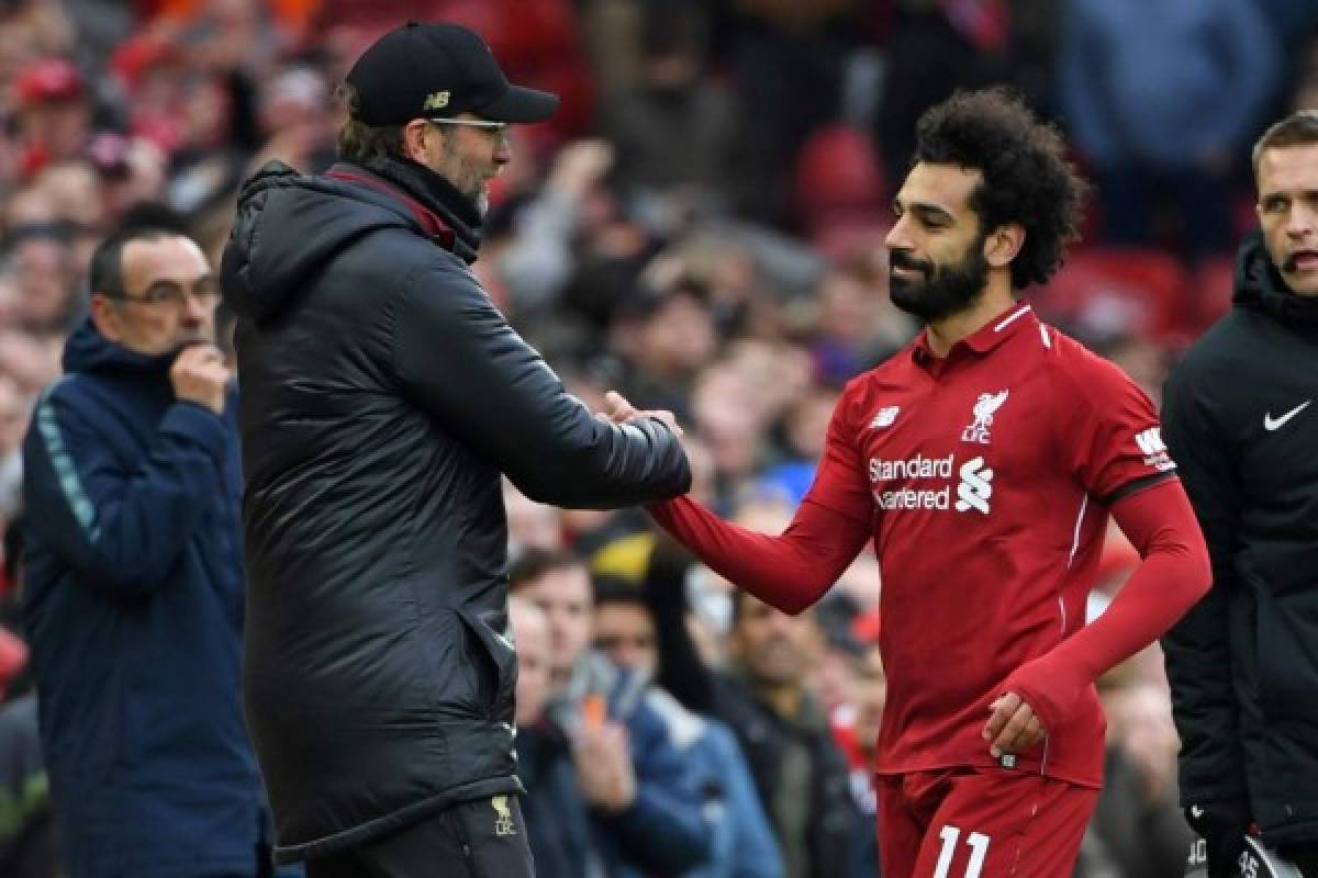 Liverpool's Egyptian midfielder Mohamed Salah (R) shakes hands with Liverpool's German manager Jurgen Klopp (L) as he's substituted during the English Premier League football match between Liverpool and Chelsea at Anfield in Liverpool, north west England on April 14, 2019. - Liverpool won the game 2-0. (Photo by Paul ELLIS / AFP) / RESTRICTED TO EDITORIAL USE. No use with unauthorized audio, video, data, fixture lists, club/league logos or 'live' services. Online in-match use limited to 120 images. An additional 40 images may be used in extra time. No video emulation. Social media in-match use limited to 120 images. An additional 40 images may be used in extra time. No use in betting publications, games or single club/league/player publications. /