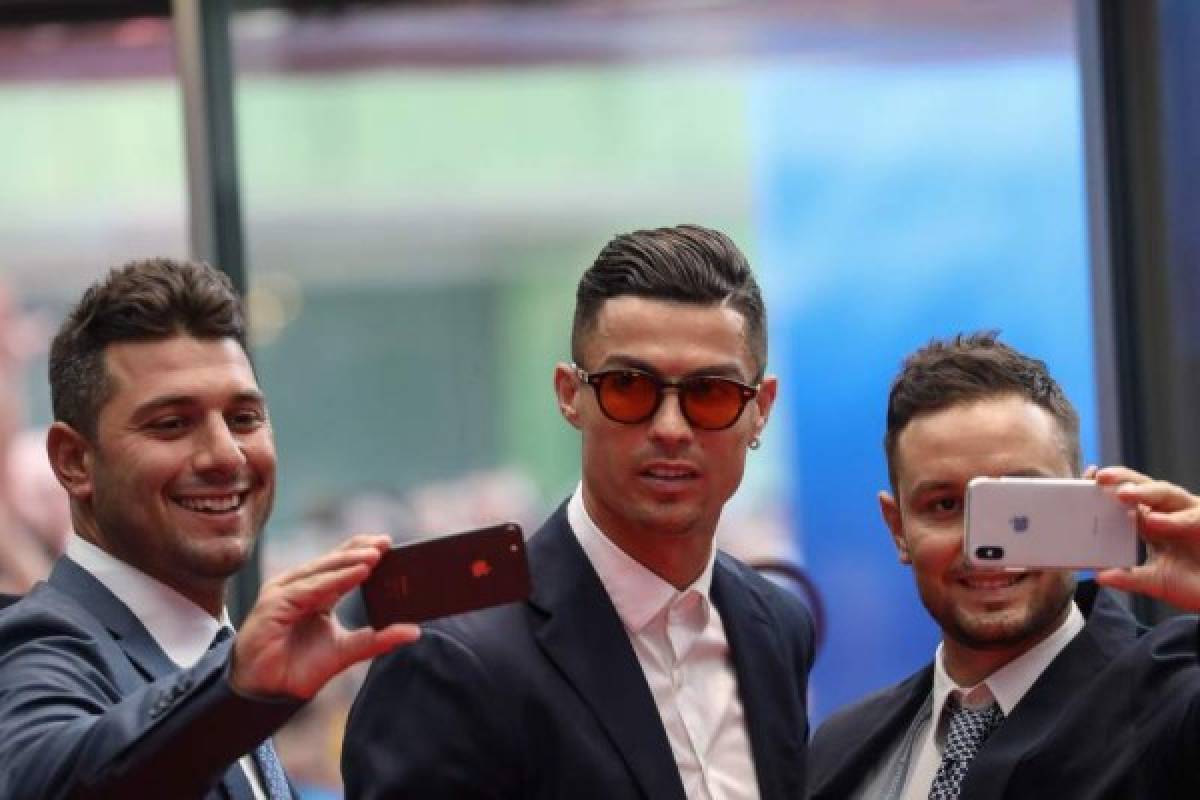 Portuguese forward Cristiano Ronaldo (C) poses for selfies as he arrives prior to the UEFA Champions League football group stage draw ceremony in Monaco on August 29, 2019. (Photo by Valery HACHE / AFP)