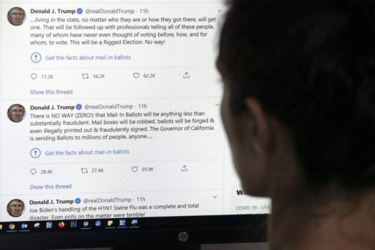 This illustration photo shows an editor in Los Angeles looking at the official Twitter account of US President Donald Trump on May 26, 2020, with two tweets by the president under which Twitter posted a link reading 'Get the facts about mail-in ballots'. - Twitter labelled two of Donald Trump's tweets misleading on May 26, a first for the social media network which has long resisted calls to censure the US President over his frequent abuse, insults and false claims. Trump's tweets contended without evidence that mail-in voting would lead to fraud and a 'Rigged Election.' (Photo by - / AFP)