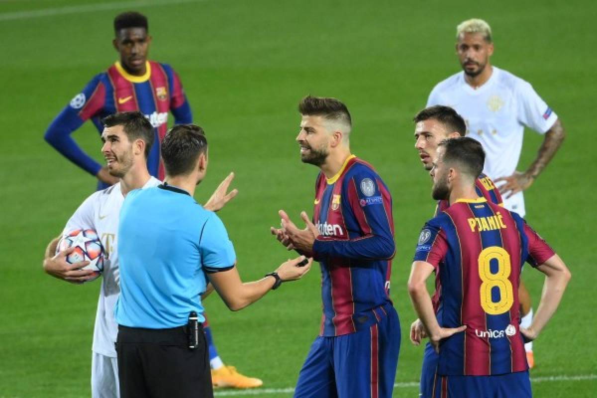 Barcelona's Spanish defender Gerard Pique (C) argues with Swiss referee Sandro Schaerer after receiving a red card during the UEFA Champions League football match between FC Barcelona and Ferencvarosi TC at the Camp Nou stadium in Barcelona on October 20, 2020. (Photo by LLUIS GENE / AFP)