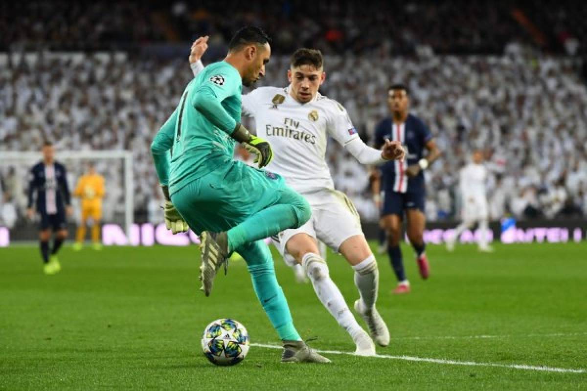 Real Madrid's Uruguayan midfielder Federico Valverde (R) challenges Paris Saint-Germain's Costa Rican goalkeeper Keylor Navas during the UEFA Champions League group A football match Real Madrid against Paris Saint-Germain FC at the Santiago Bernabeu stadium in Madrid on November 26, 2019. (Photo by GABRIEL BOUYS / AFP)