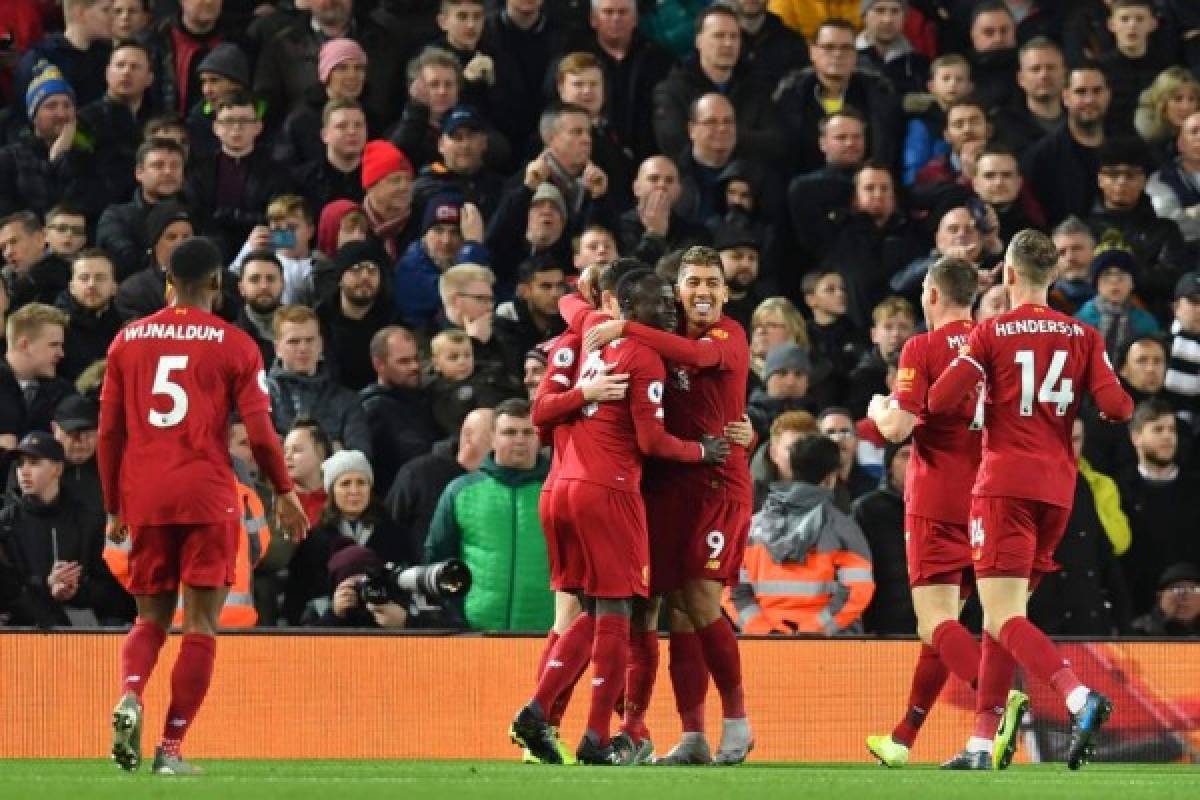 Liverpool's Egyptian midfielder Mohamed Salah celebrates with teammates after scoring his team's first goal during the English Premier League football match between Liverpool and Sheffield United at Anfield in Liverpool, north west England on January 2, 2020. (Photo by Paul ELLIS / AFP) / RESTRICTED TO EDITORIAL USE. No use with unauthorized audio, video, data, fixture lists, club/league logos or 'live' services. Online in-match use limited to 120 images. An additional 40 images may be used in extra time. No video emulation. Social media in-match use limited to 120 images. An additional 40 images may be used in extra time. No use in betting publications, games or single club/league/player publications. /
