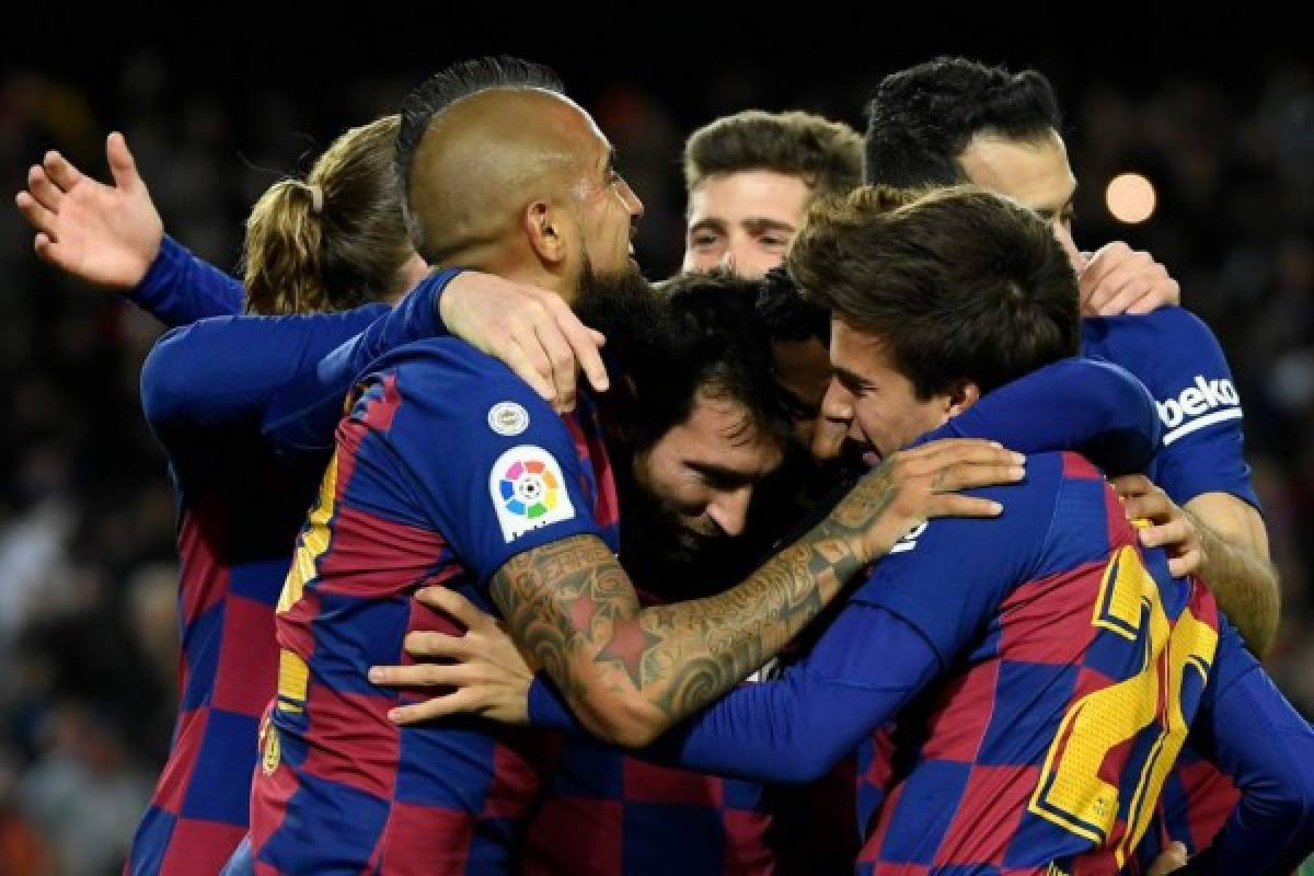 Barcelona's Argentine forward Lionel Messi (C) celebrates with teammates after scoring the opening goal during the Spanish league football match between FC Barcelona and Granada FC at the Camp Nou stadium in Barcelona on January 19, 2020. (Photo by LLUIS GENE / AFP)