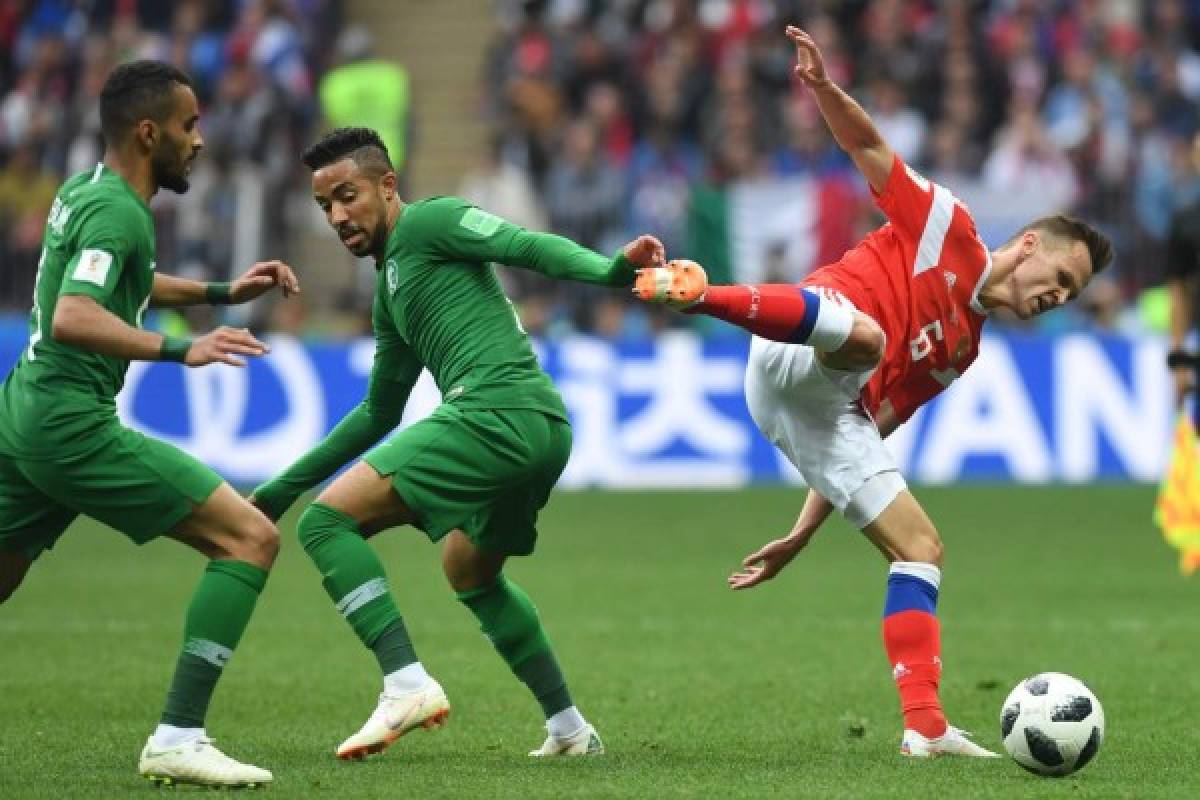 Saudi Arabia's midfielder Hatan Babhir (C) vies with Russia's midfielder Denis Cheryshev during the Russia 2018 World Cup Group A football match between Russia and Saudi Arabia at the Luzhniki Stadium in Moscow on June 14, 2018. / AFP PHOTO / Francisco LEONG / RESTRICTED TO EDITORIAL USE - NO MOBILE PUSH ALERTS/DOWNLOADS