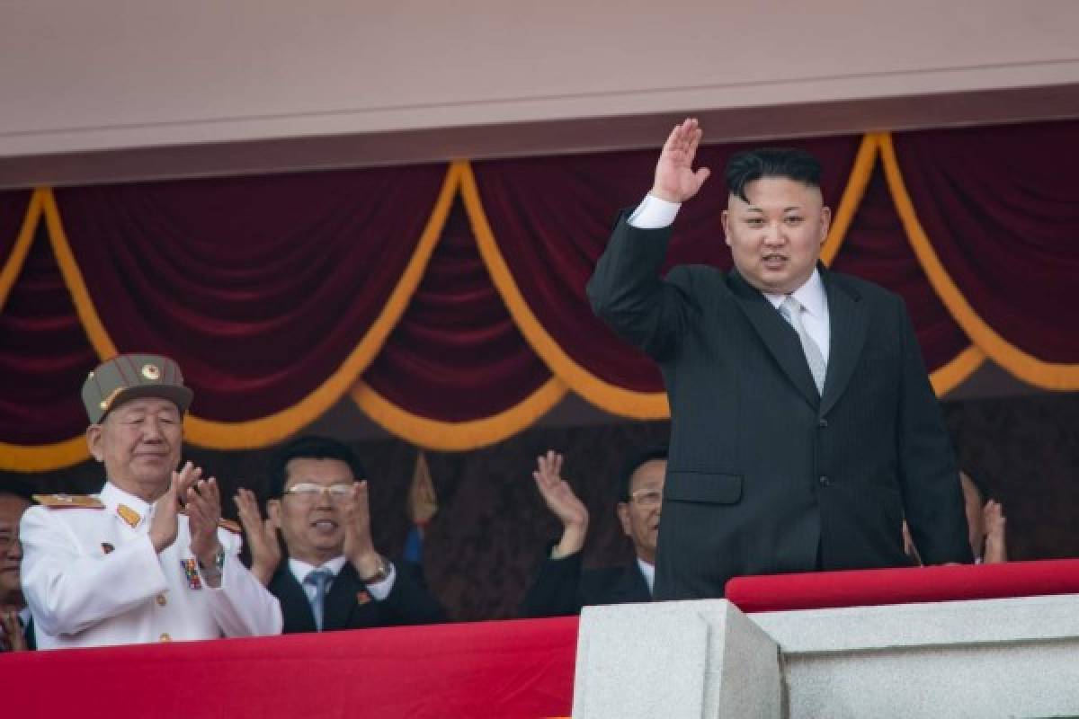 North Korean leader Kim Jong-Un (R) waves from a balcony of the Grand People's Study house following a military parade marking the 105th anniversary of the birth of late North Korean leader Kim Il-Sung, in Pyongyang on April 15, 2017. Kim saluted as ranks of goose-stepping soldiers followed by tanks and other military hardware paraded in Pyongyang for a show of strength with tensions mounting over his nuclear ambitions. / AFP PHOTO / ED JONES