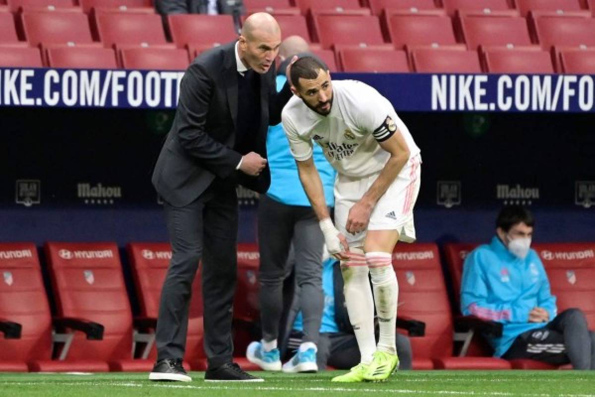 Real Madrid's French coach Zinedine Zidane (L) talks to Real Madrid's French forward Karim Benzema during the Spanish league football match Club Atletico de Madrid against Real Madrid CF at the Wanda Metropolitano stadium in Madrid on March 7, 2021. (Photo by JAVIER SORIANO / AFP)