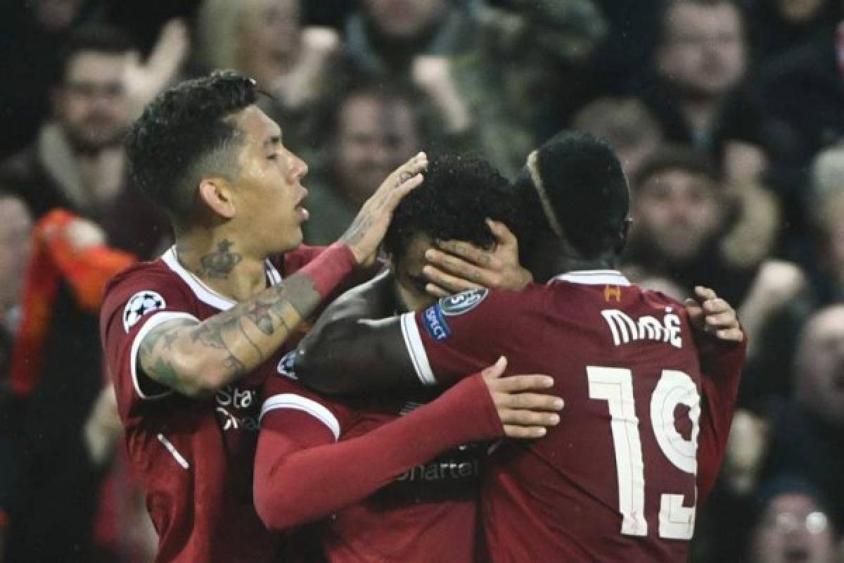 Liverpool's Egyptian midfielder Mohamed Salah (C) celebrates with Liverpool's Brazilian midfielder Roberto Firmino and Liverpool's Senegalese midfielder Sadio Mane (R) after scoring during the UEFA Champions League first leg semi-final football match between Liverpool and Roma at Anfield stadium in Liverpool, north west England on April 24, 2018. / AFP PHOTO / Filippo MONTEFORTE
