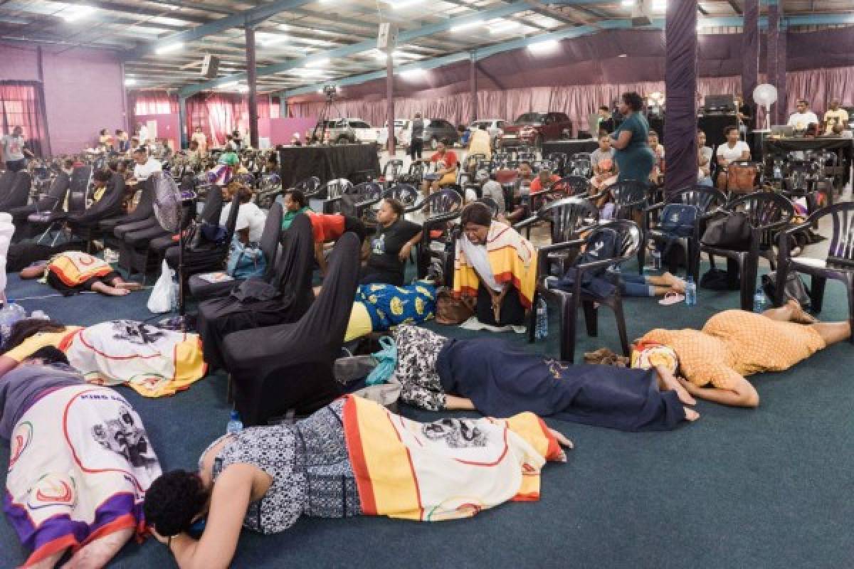 Worshippers from the Nala Mandate Church heed the call to pray under the theme Prayer of Divine Restraining Order Against Corona Virus by King Somnala, head of the Nala Mandate Church, in Durban on March 19, 2020. - The church is a faith healing organisation believing in miracles and practise healing under prophetic instruction of the Holy Spirit. (Photo by RAJESH JANTILAL / AFP)