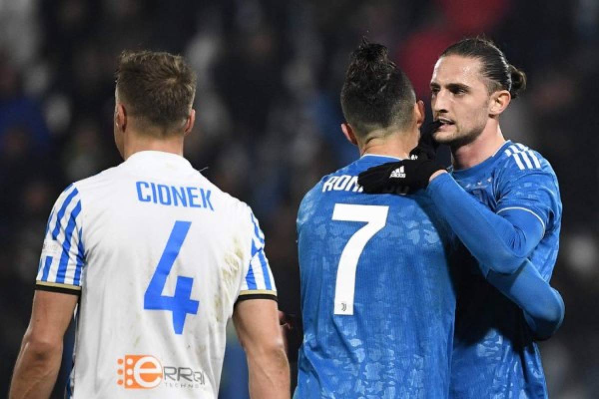 Juventus' Portuguese forward Cristiano Ronaldo embraces Juventus' French midfielder Adrien Rabiot (R) next to Spal's Polish defender Thiago Cionek at the end of the Italian Serie A football match SPAL vs Juventus on February 22, 2020 at the Paolo-Mazza stadium in Ferrara. (Photo by Isabella BONOTTO / AFP)