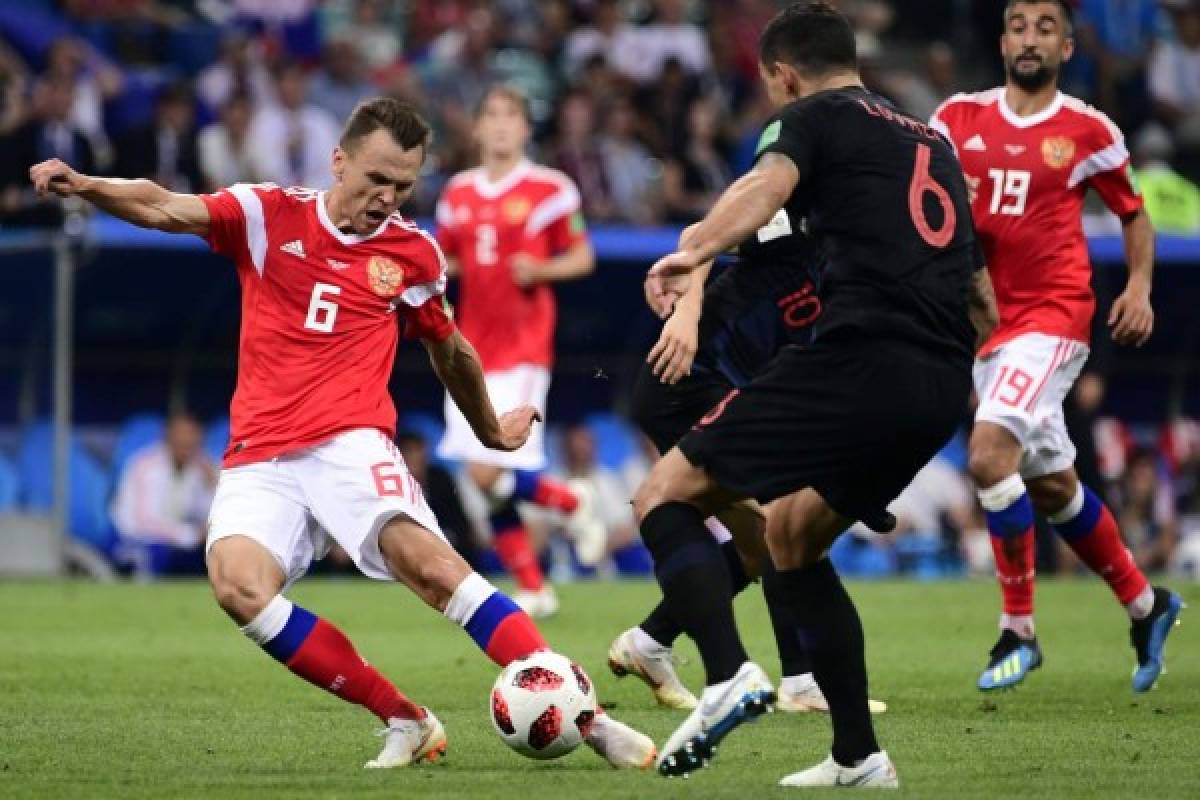 Russia's midfielder Denis Cheryshev (L) kicks the ball to score a goal past Croatia's defender Dejan Lovren (R) during the Russia 2018 World Cup quarter-final football match between Russia and Croatia at the Fisht Stadium in Sochi on July 7, 2018. / AFP PHOTO / PIERRE-PHILIPPE MARCOU / RESTRICTED TO EDITORIAL USE - NO MOBILE PUSH ALERTS/DOWNLOADS