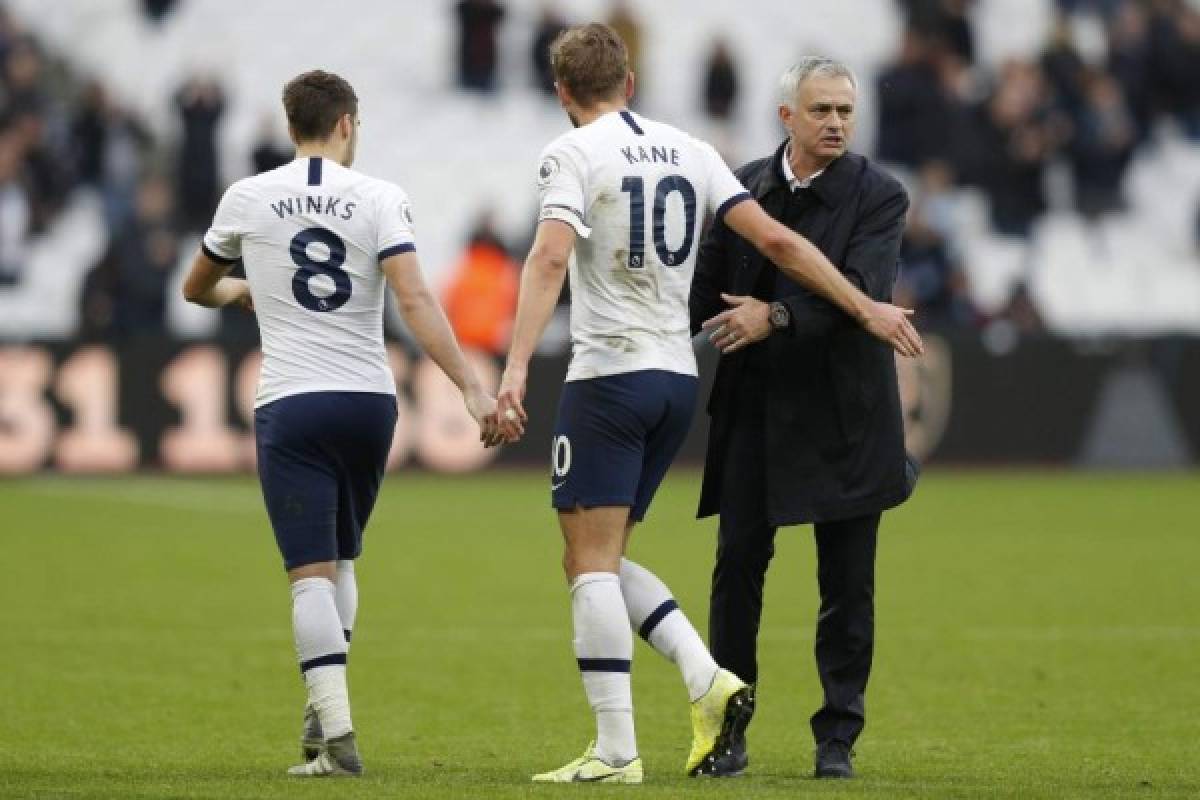 Tottenham Hotspur's Portuguese head coach Jose Mourinho interacts with Tottenham Hotspur's English striker Harry Kane (C) and Tottenham Hotspur's English midfielder Harry Winks (L) at the final whistle during the English Premier League football match between West Ham United and Tottenham Hotspur at The London Stadium, in east London on November 23, 2019. - Tottenham Hotspur beat West Ham United 3-2. (Photo by Adrian DENNIS / AFP) / RESTRICTED TO EDITORIAL USE. No use with unauthorized audio, video, data, fixture lists, club/league logos or 'live' services. Online in-match use limited to 120 images. An additional 40 images may be used in extra time. No video emulation. Social media in-match use limited to 120 images. An additional 40 images may be used in extra time. No use in betting publications, games or single club/league/player publications. /