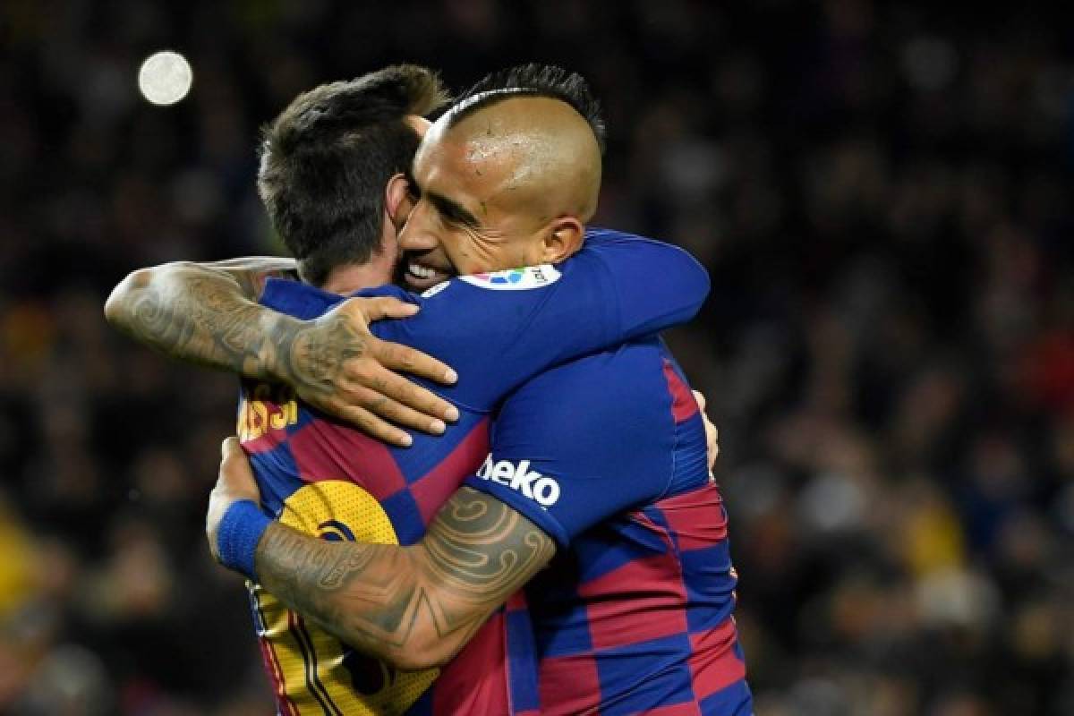 Barcelona's Argentine forward Lionel Messi (L) is congratulated by Barcelona's Chilean midfielder Arturo Vidal for scoring the opening goal during the Spanish league football match between FC Barcelona and Granada FC at the Camp Nou stadium in Barcelona on January 19, 2020. (Photo by LLUIS GENE / AFP)