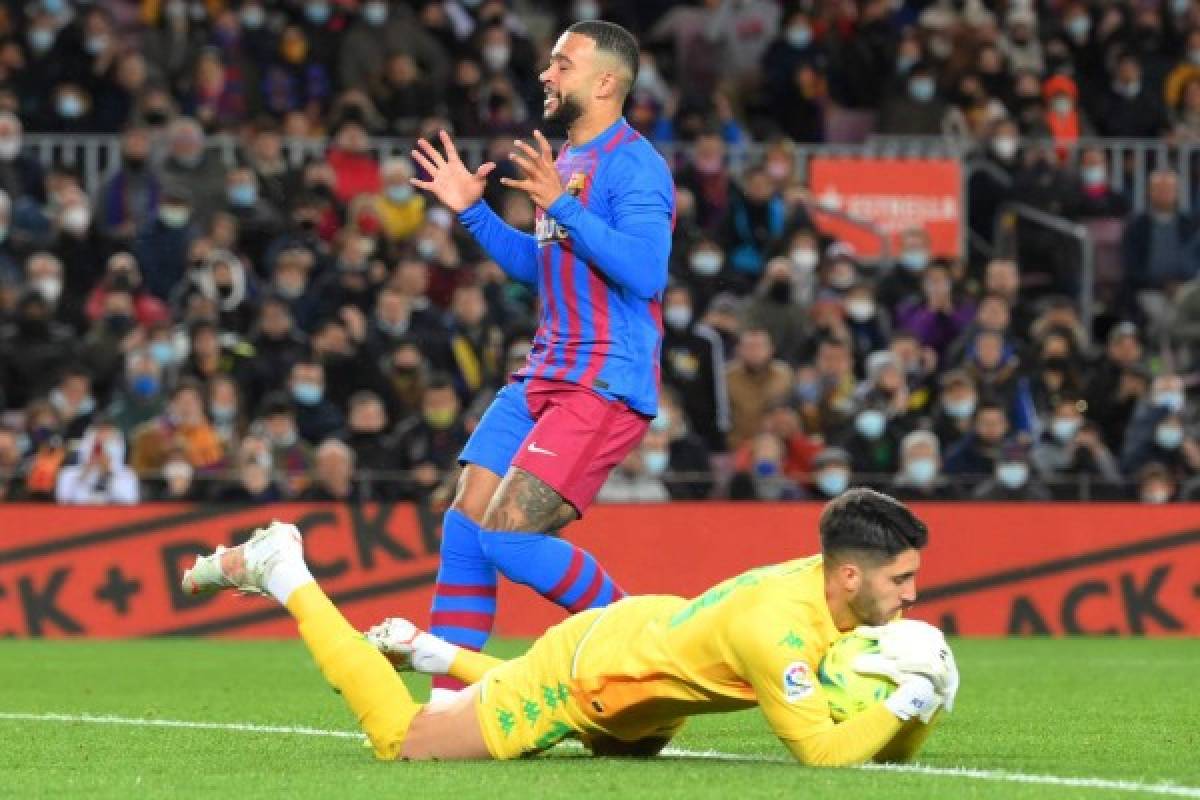 Barcelona's Dutch forward Memphis Depay (TOP) reacts to missing a goal opportunity during the Spanish League football match between FC Barcelona and Real Betis at the Camp Nou stadium in Barcelona on December 4, 2021. (Photo by LLUIS GENE / AFP)