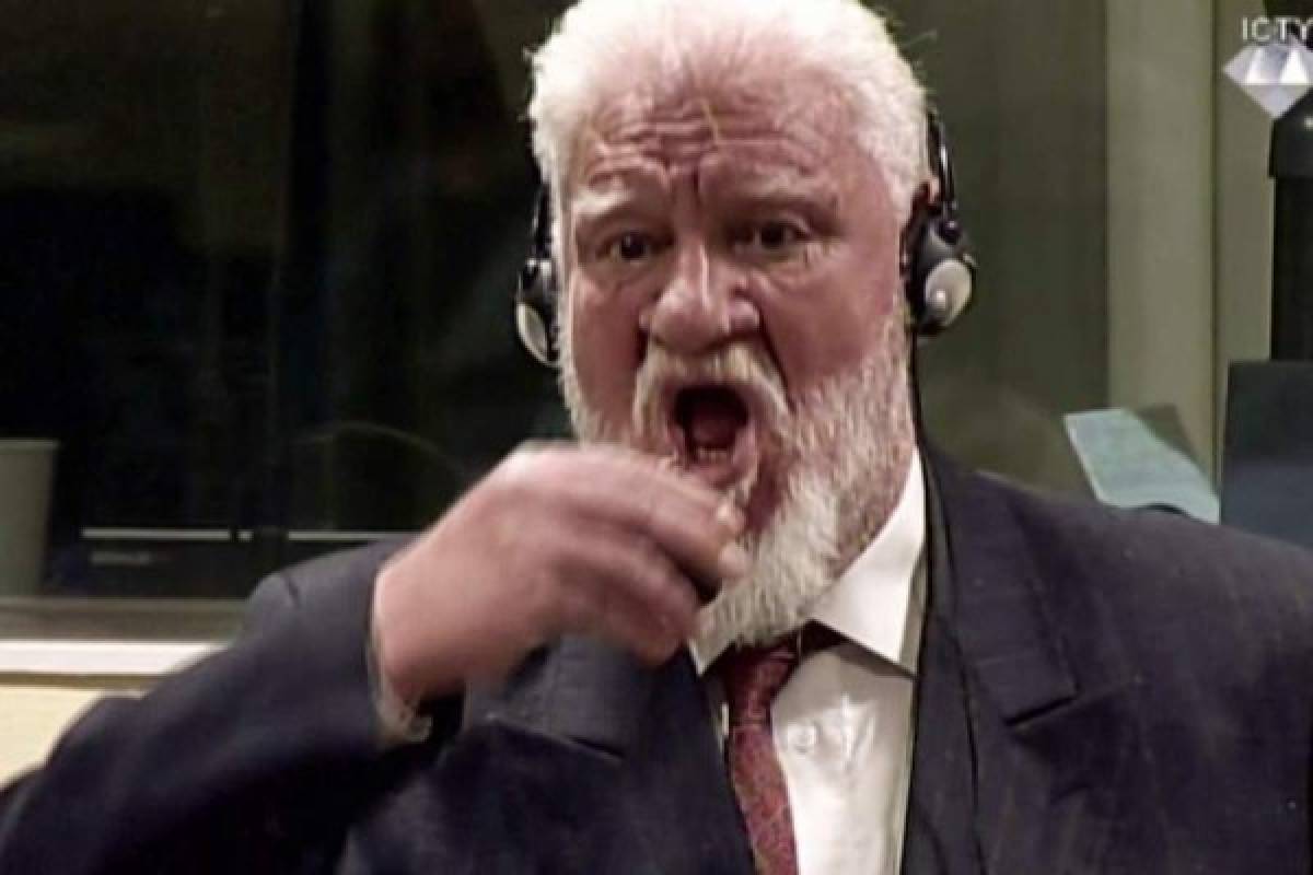 This videograb taken from live footage of the International Criminal Court, shows Croatian former general Slobodan Praljak swallowing what is believed to be poison, during his judgement at the UN war crimes court to protest the upholding of a 20-year jail term.Former Bosnian Croat military leader Slobodan Praljak was alive and being treated by medics. / AFP PHOTO / International Criminal Tribunal for the former Yugoslavia / - / RESTRICTED TO EDITORIAL USE - MANDATORY CREDIT 'AFP PHOTO / ICTY' - NO MARKETING NO ADVERTISING CAMPAIGNS - DISTRIBUTED AS A SERVICE TO CLIENTS