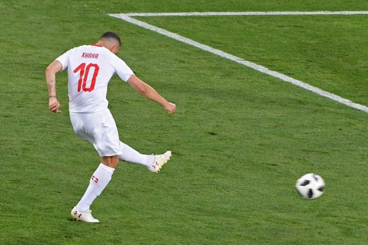 Switzerland's midfielder Granit Xhaka (L) scores his team's first goal during the Russia 2018 World Cup Group E football match between Serbia and Switzerland at the Kaliningrad Stadium in Kaliningrad on June 22, 2018. / AFP PHOTO / Patrick HERTZOG / RESTRICTED TO EDITORIAL USE - NO MOBILE PUSH ALERTS/DOWNLOADS