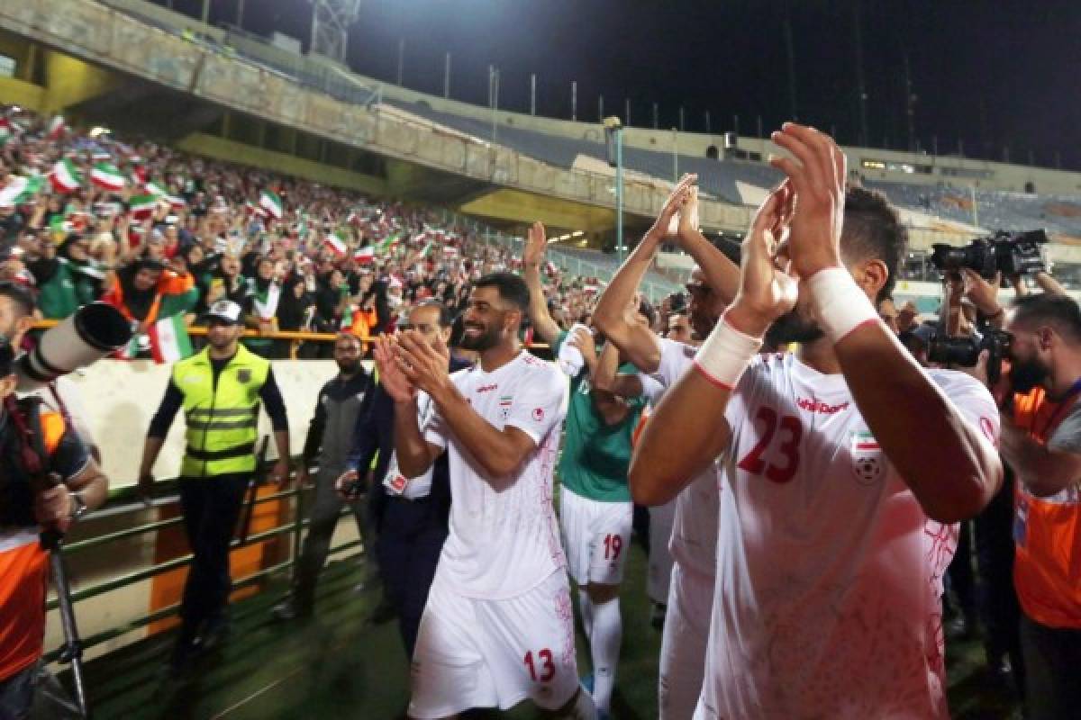 Iranian players greet their fans after the World Cup Qatar 2022 Group C qualification football match between Iran and Cambodia at the Azadi stadium in the capital Tehran on October 10, 2019. (Photo by ATTA KENARE / AFP)