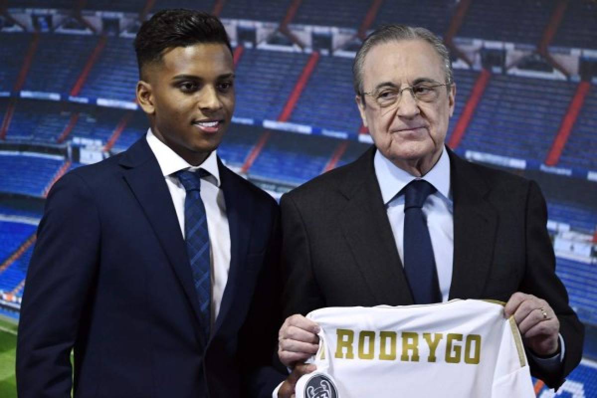 Brazilian forward Rodrygo Silva de Goes (L) poses with Real Madrid's president Florentino Perez holding the player's new jersey during the official presentation of Silva as new player of the Spanish club at the Santiago Bernabeu stadium in Madrid on June 18, 2019. (Photo by OSCAR DEL POZO / AFP)