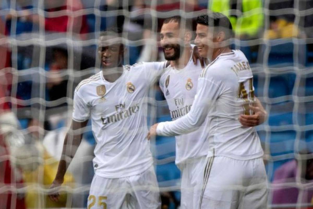Real Madrid's French forward Karim Benzema (C) celebrates with Real Madrid's Colombian midfielder James Rodriguez (R) and Real Madrid's Brazilian forward Vinicius Junior after scoring during the Spanish league football match Real Madrid CF against Levante UD at the Santiago Bernabeu stadium in Madrid on September 14, 2019. (Photo by CURTO DE LA TORRE / AFP)
