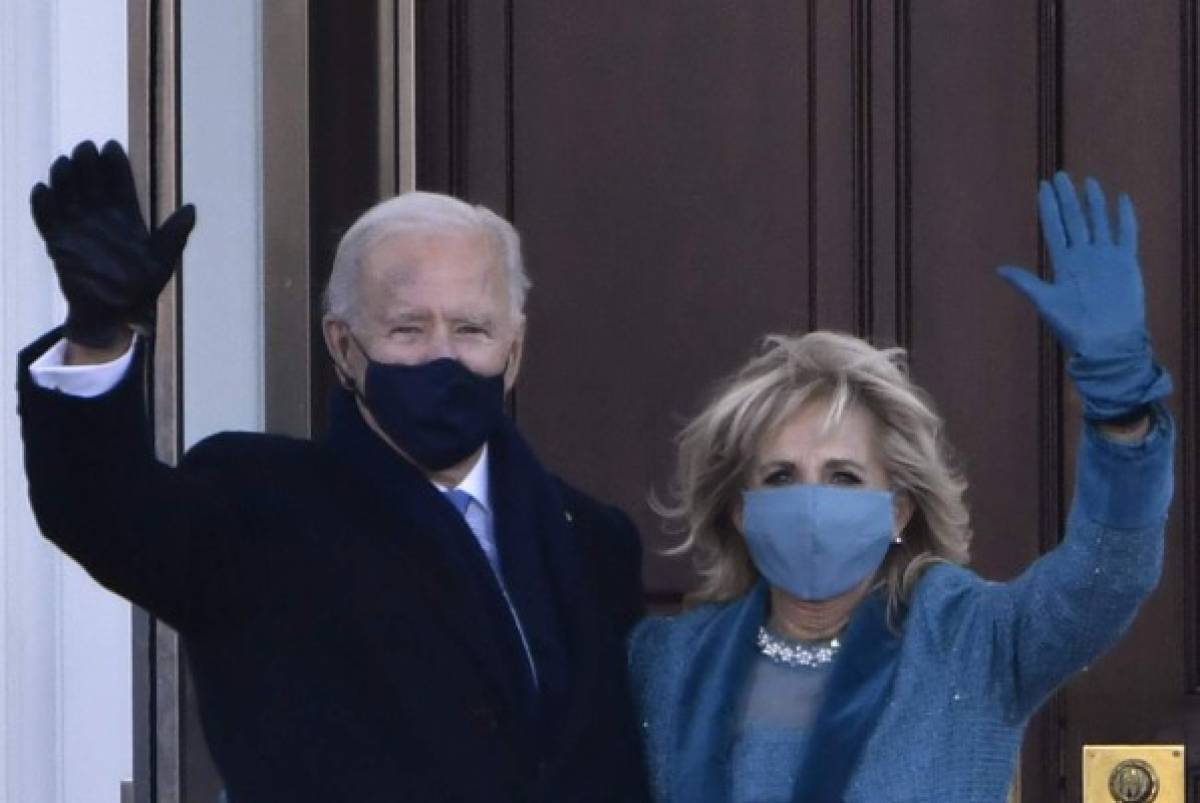 US President Joe Biden and First Lady Jill Biden wave as they arrive at the White House in Washington, DC, on January 20, 2021. (Photo by Patrick T. FALLON / AFP)