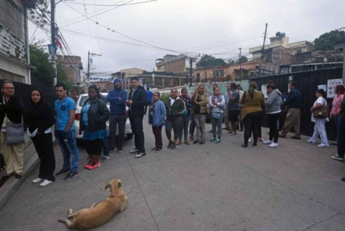 Voters queue outside a polling station in Tegucigalpa during the general election, on November 26, 2017.Honduras' six million voters are to cast ballots in a controversial election Sunday in which President Juan Orlando Hernandez is seeking a second mandate despite a constitutional one-term limit. This small country is at the heart of Central America's 'triangle of death,' an area plagued by gangs and poverty. / AFP PHOTO / RODRIGO ARANGUA