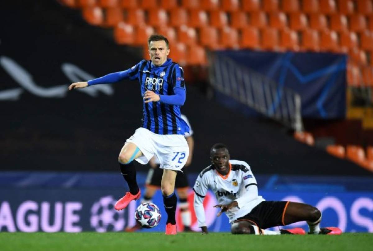Atalanta's Slovenian midfielder Josip Ilicic (L) controls the ball as Valencia's French defender Mouctar Diakhaby looks on during the UEFA Champions League round of 16 second leg match between Valencia CF and Atalanta at Estadio Mestalla on March 10, 2020 in Valencia. (Photo by - / POOL UEFA / AFP)