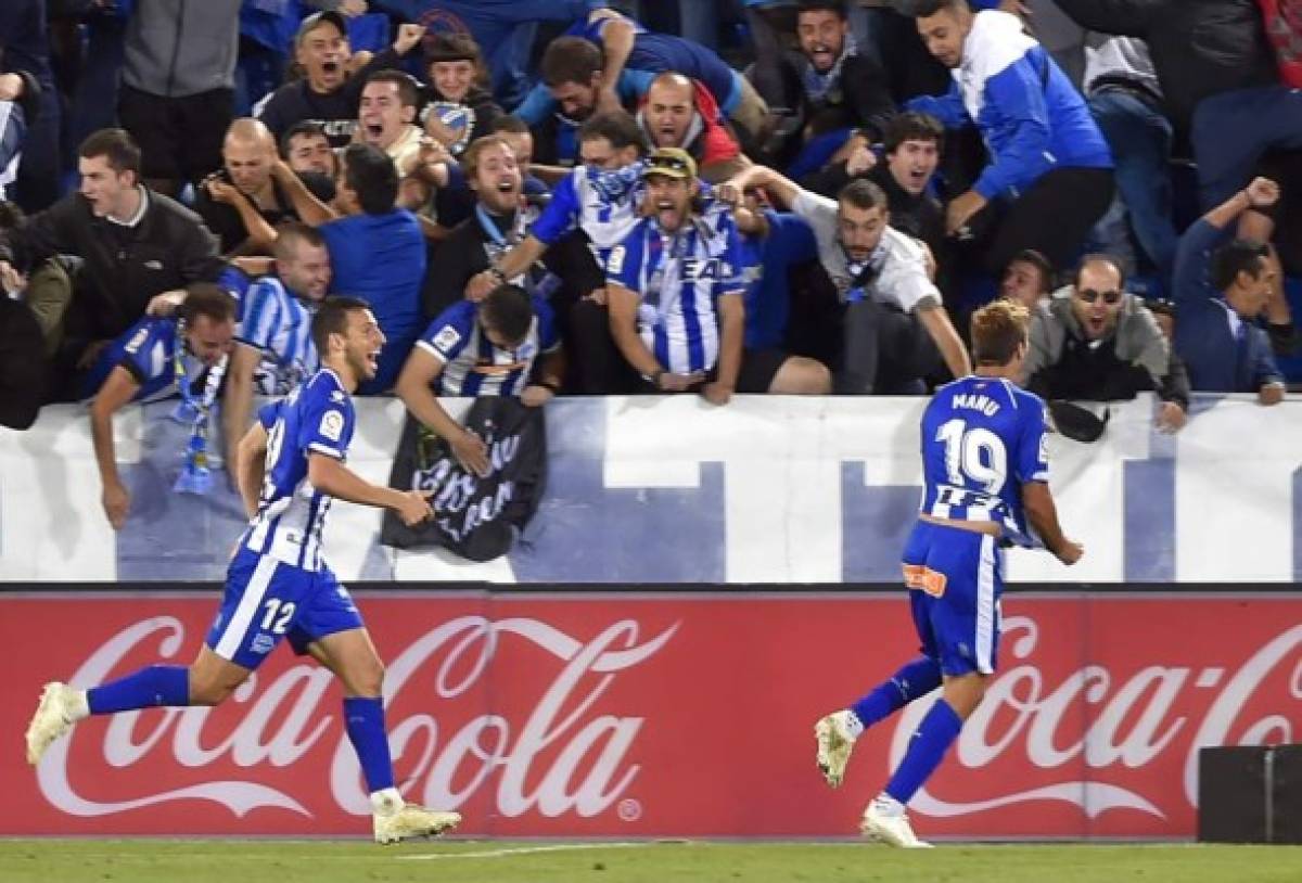 Spanish midfielder Manuel Alejandro celebrates scoring a goal with Alaves' Argentinian forward Calleri (L) during the Spanish league football match between Deportivo Alaves and Real Madrid CF at the Mendizorroza stadium in Vitoria on October 6, 2018. / AFP PHOTO / ANDER GILLENEA